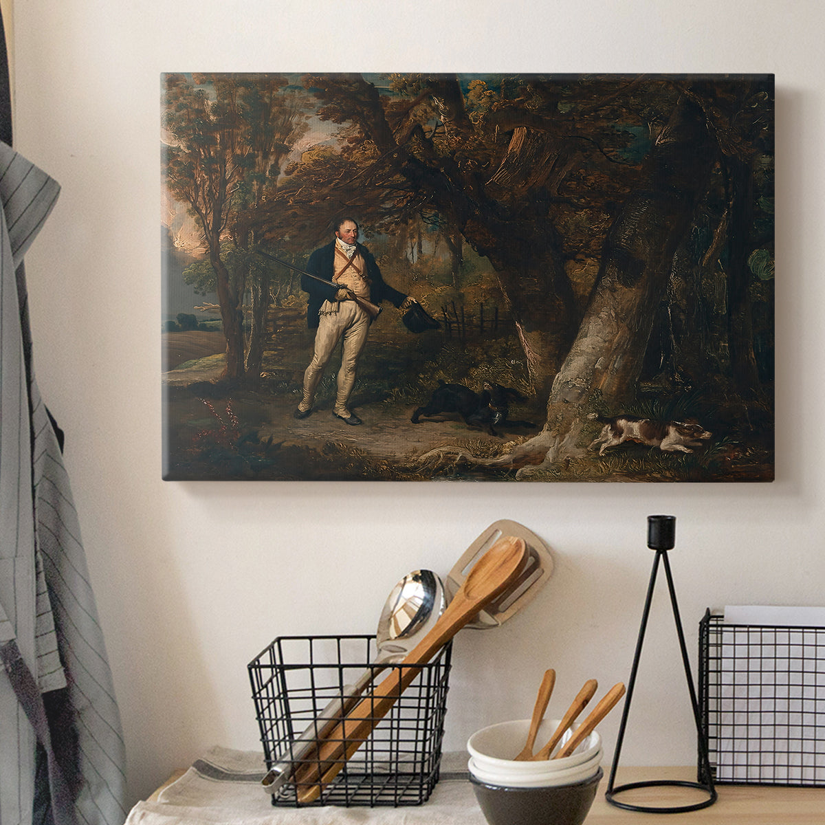 Canvas art print detailing a detailed outdoor scene of man with dogs, displayed in a softly lit workspace setting