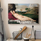 Canvas art print detailing a classical reclining nude surrounded by gentle landscape, displayed in a softly lit workspace setting