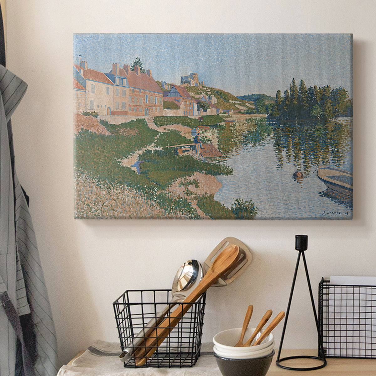 Canvas art print detailing a pointillist composition with town and natural surroundings, displayed in a softly lit workspace setting