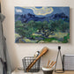 Canvas art print detailing a rural composition emphasizing contrast between trees and mountains, displayed in a softly lit workspace setting