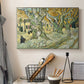 Canvas art print detailing a landscape featuring tall trunks and figures in shaded area, displayed in a softly lit workspace setting