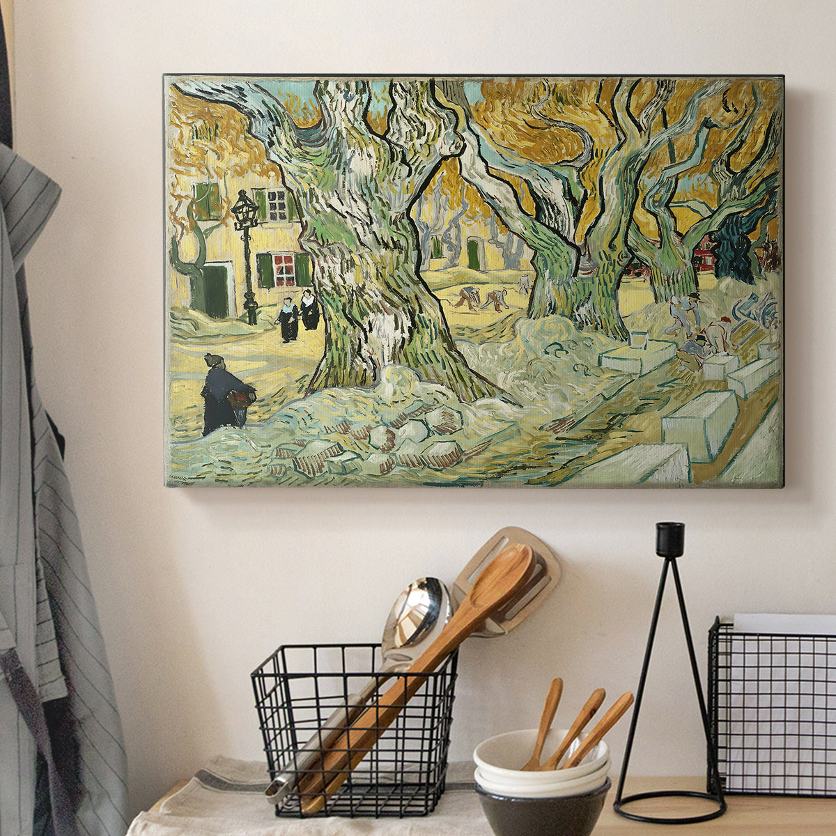 Canvas art print detailing a landscape featuring tall trunks and figures in shaded area, displayed in a softly lit workspace setting