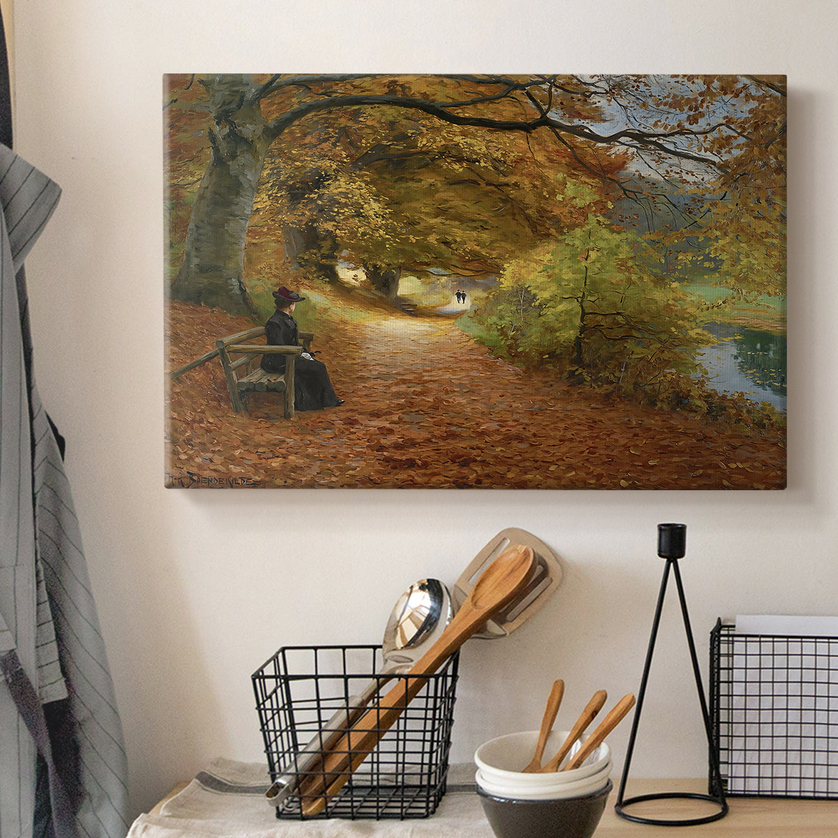 Canvas art print detailing a peaceful autumn setting with figures in wooded environment, displayed in a softly lit workspace setting