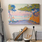 Canvas art print detailing a coastal composition with land and water in balance, displayed in a softly lit workspace setting