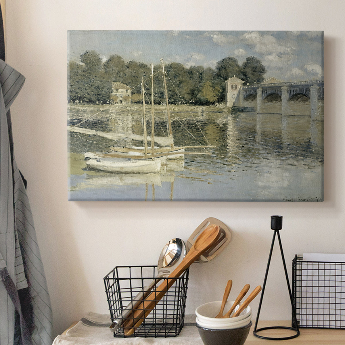 Canvas art print detailing a riverside view with architecture and nautical activity, displayed in a softly lit workspace setting