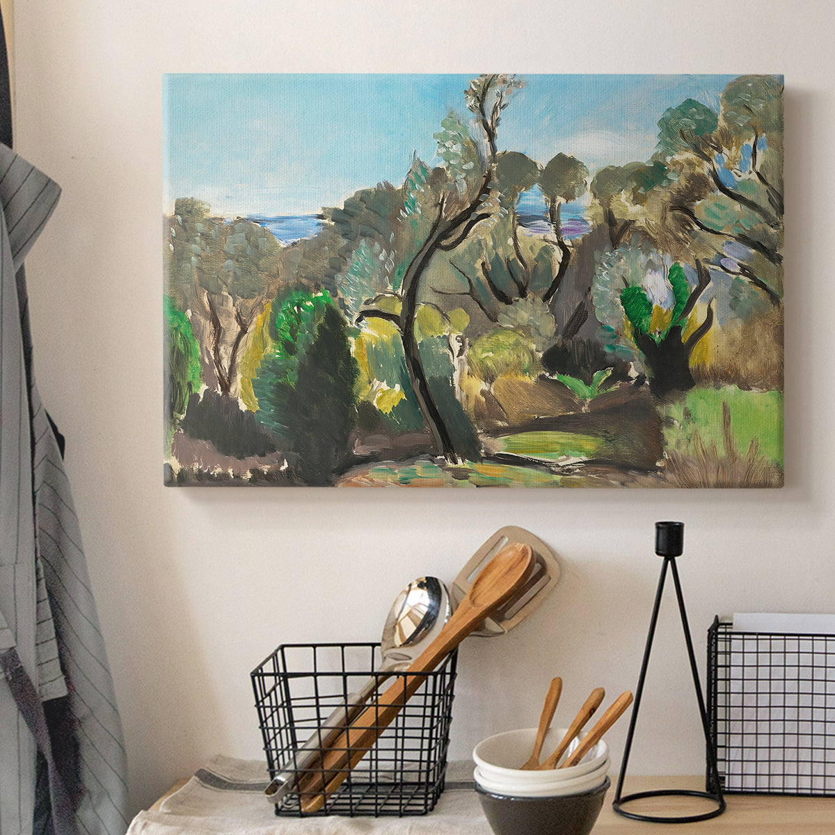 Canvas art print detailing an open terrain scene with trees and atmospheric depth, displayed in a softly lit workspace setting
