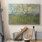 Canvas art print detailing a stylized orchard composition with delicate tones, displayed in a softly lit workspace setting
