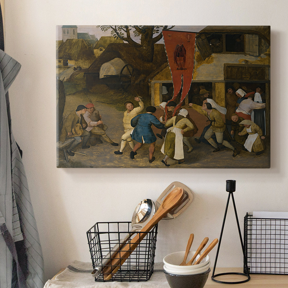 Canvas art print detailing a traditional celebration in rural scene, displayed in a softly lit workspace setting