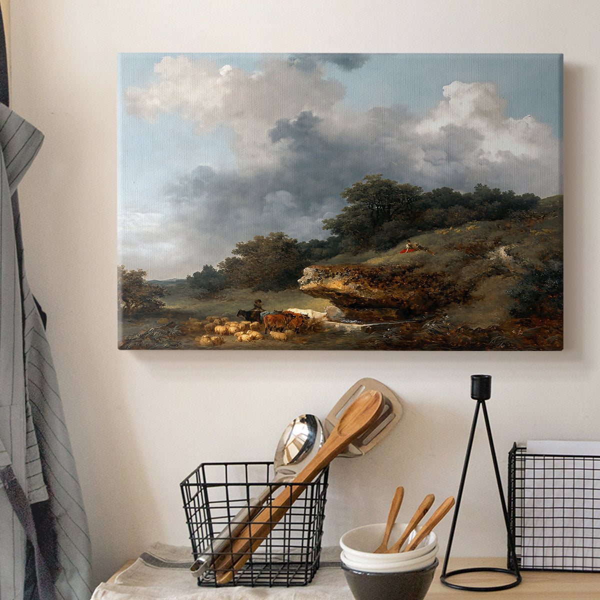 Canvas art print detailing a rural composition featuring water, figures, and animals, displayed in a softly lit workspace setting