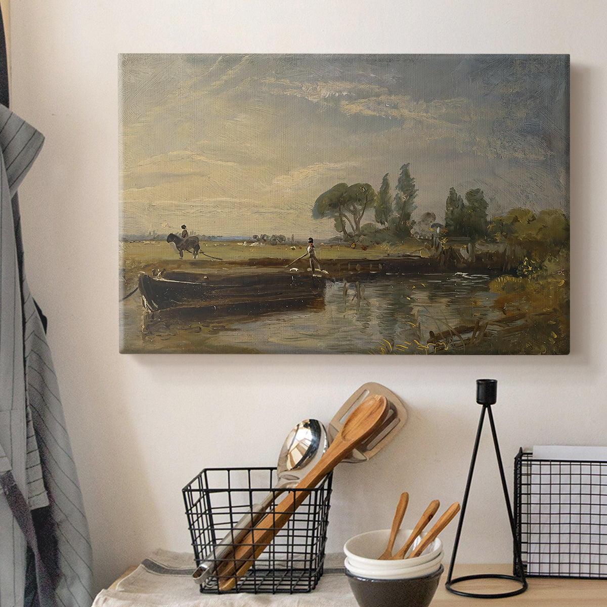 Canvas art print detailing a countryside view with barge and waterway, displayed in a softly lit workspace setting