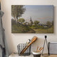 Canvas art print detailing a pastoral view with church structure in natural setting, displayed in a softly lit workspace setting