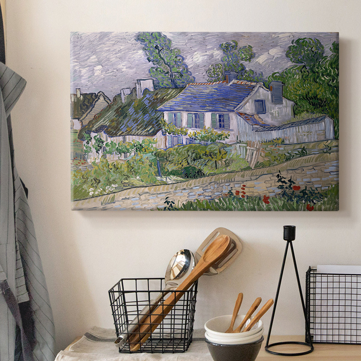 Canvas art print detailing a stylized composition featuring houses and landscape, displayed in a softly lit workspace setting
