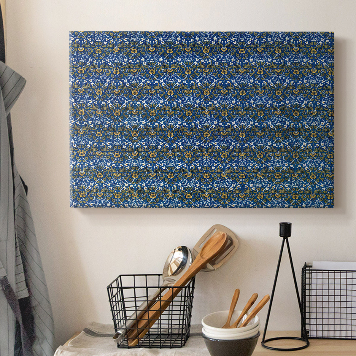 Canvas art print detailing a textile-style surface filled with small leaves and blossoms, displayed in a softly lit workspace setting