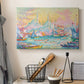 Canvas art print detailing a coastal cityscape, displayed in a softly lit workspace setting