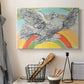 Canvas art print detailing a graphic depiction of bird with rainbow, displayed in a softly lit workspace setting