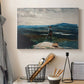 Canvas art print detailing a quiet lake scene with lone person and open horizon, displayed in a softly lit workspace setting