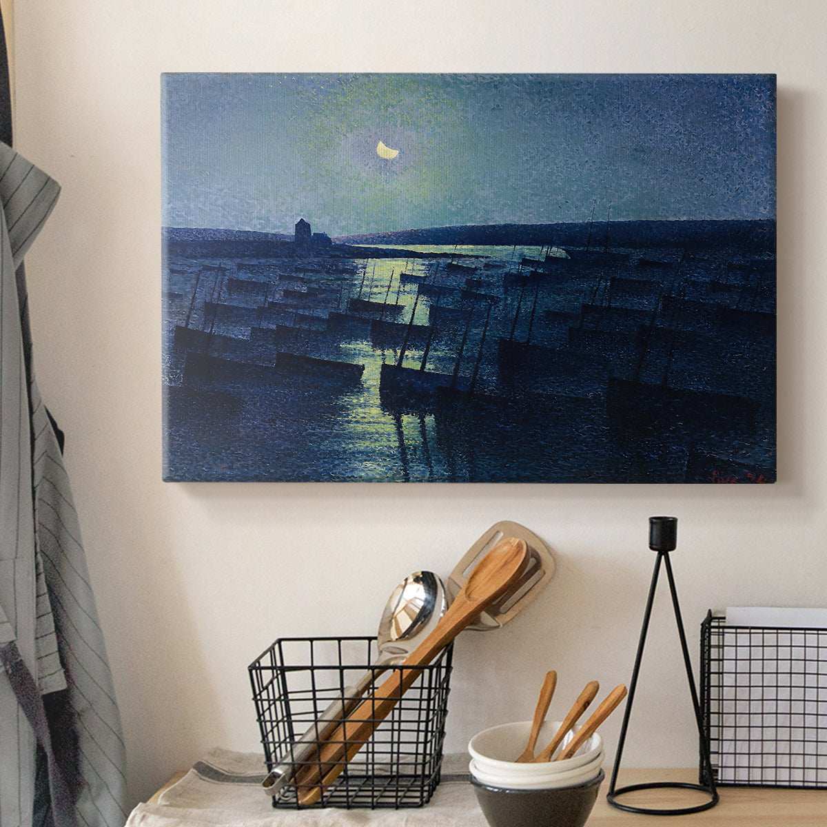 Canvas art print detailing an atmospheric harbor illuminated by moonlight, displayed in a softly lit workspace setting