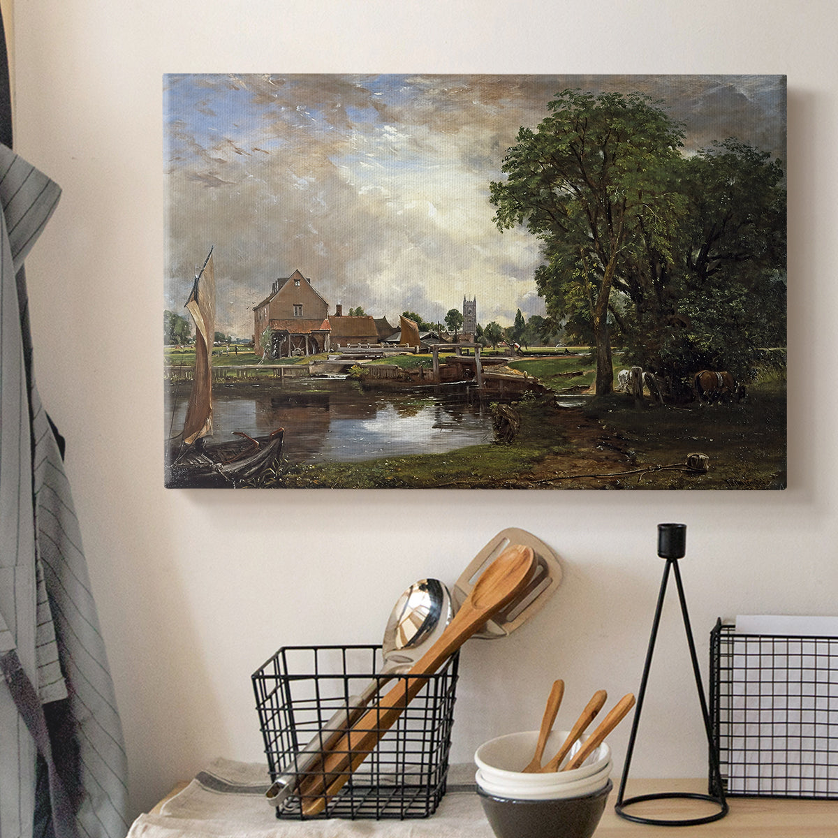 Canvas art print detailing a countryside view with mill and canal, displayed in a softly lit workspace setting
