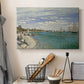 Canvas art print detailing a nautical scene with boats racing near seaside town, displayed in a softly lit workspace setting