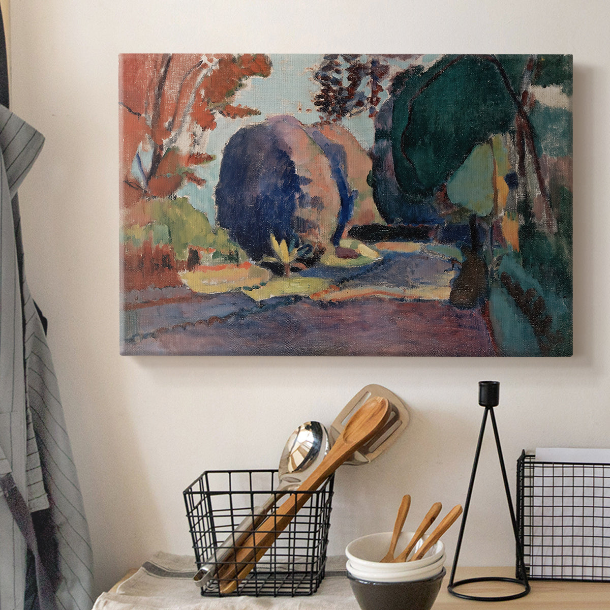 Canvas art print detailing a colorful landscape view of a garden, displayed in a softly lit workspace setting