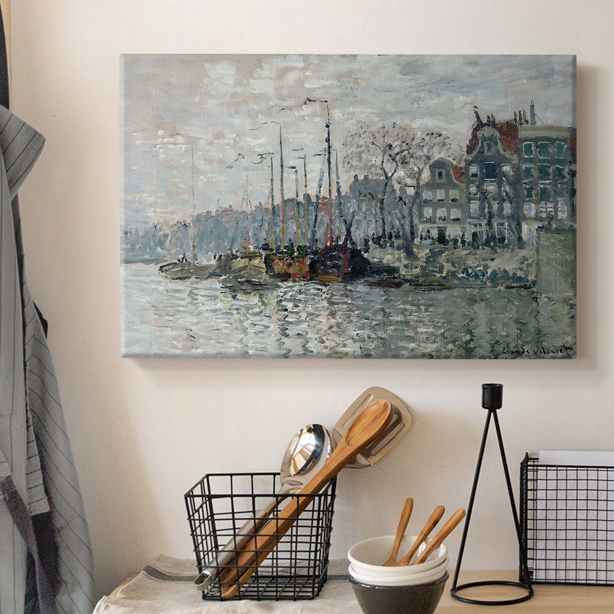 Canvas art print detailing a harbor view with masts, houses, and reflections in water, displayed in a softly lit workspace setting