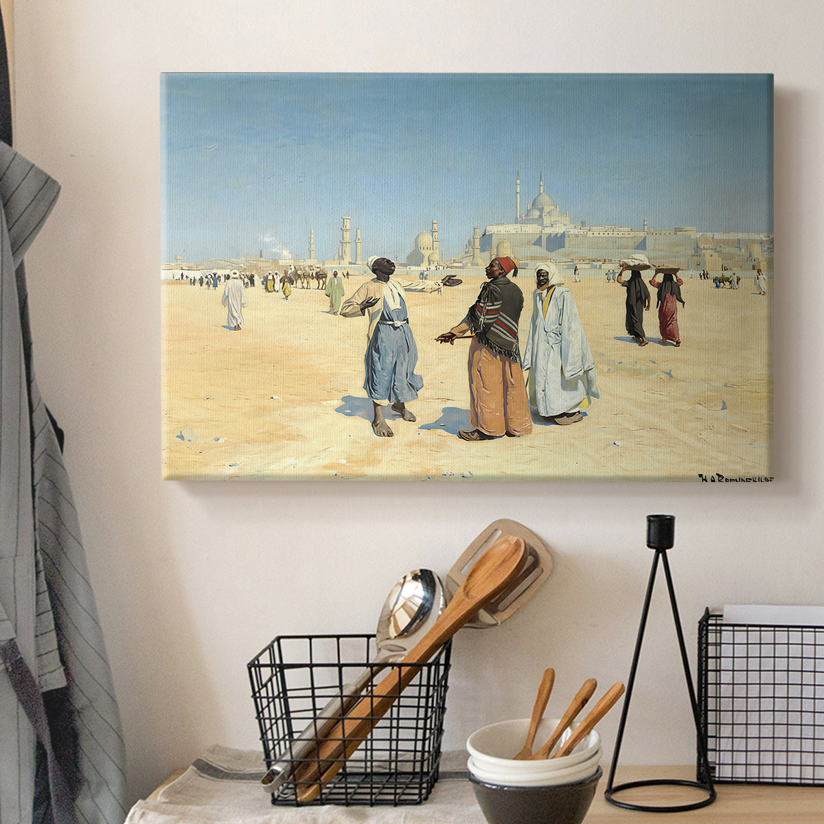 Canvas art print detailing a cultural landscape with desert foreground and historic structures, displayed in a softly lit workspace setting