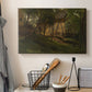 Canvas art print detailing a rural composition with buildings nestled among greenery, displayed in a softly lit workspace setting