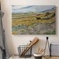 Canvas art print detailing a countryside composition showing agricultural labor in enclosed field, displayed in a softly lit workspace setting