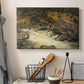 Canvas art print detailing a forested setting with stream descending over rocks, displayed in a softly lit workspace setting