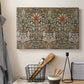 Canvas art print detailing a botanical motif with repeating curved stems on dark ground, displayed in a softly lit workspace setting