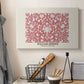 Canvas art print detailing a textile composition featuring symmetrical flower motifs, displayed in a softly lit workspace setting