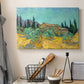 Canvas art print detailing a stylized rural setting with trees and structures, displayed in a softly lit workspace setting