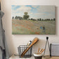 Canvas art print detailing a rural landscape with scattered figures among blooming flowers, displayed in a softly lit workspace setting