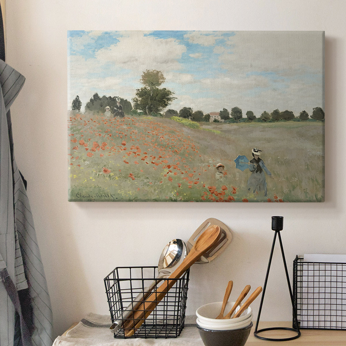 Canvas art print detailing a rural landscape with scattered figures among blooming flowers, displayed in a softly lit workspace setting