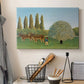 Canvas art print detailing a stylized rural setting with grassland and trees, displayed in a softly lit workspace setting