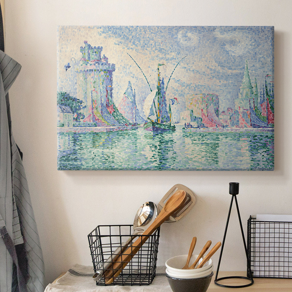 Canvas art print detailing a coastal composition with buildings, displayed in a softly lit workspace setting