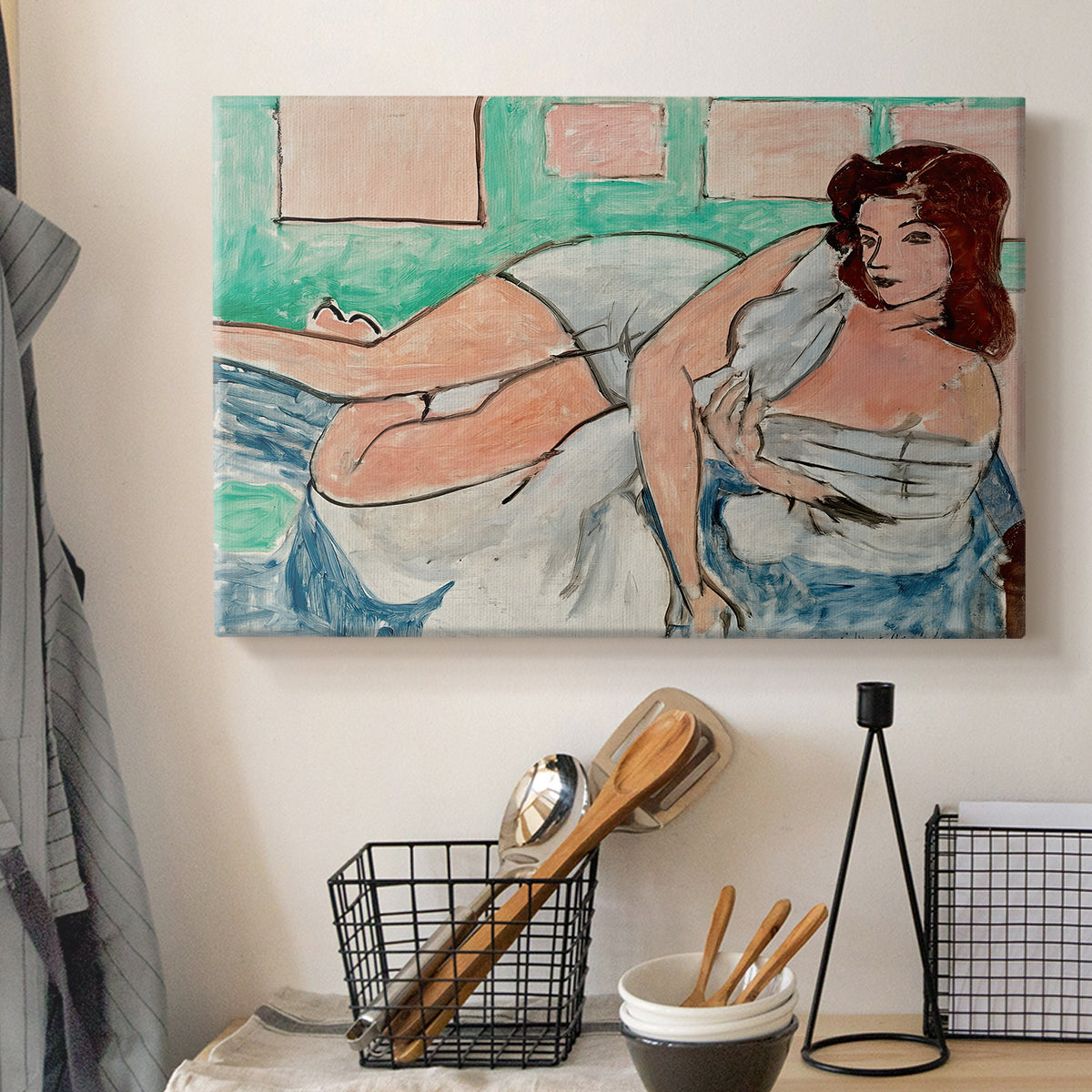 Canvas art print detailing a stylized female figure in a relaxed pose with drapery, displayed in a softly lit workspace setting