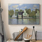 Canvas art print detailing a waterfront architecture with still reflections, displayed in a softly lit workspace setting