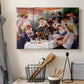 Canvas art print detailing a social dining scene with figures seated around table on riverside terrace, displayed in a softly lit workspace setting