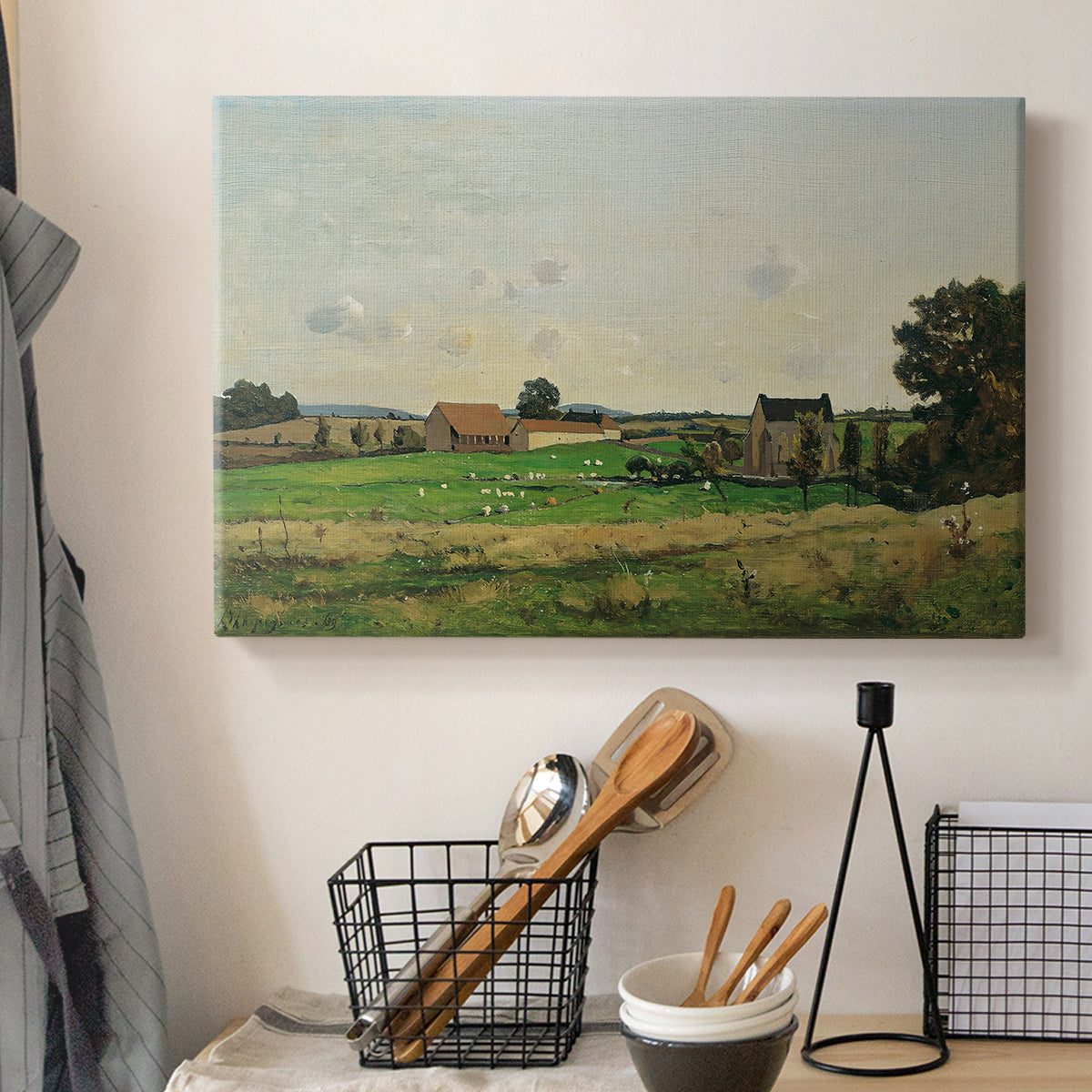 Canvas art print detailing a peaceful landscape with structure and open terrain, displayed in a softly lit workspace setting