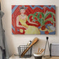 Canvas art print detailing a colorful portrait of a woman in an interior setting, displayed in a softly lit workspace setting