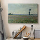 Canvas art print detailing a natural field scene with vibrant red flowers, displayed in a softly lit workspace setting