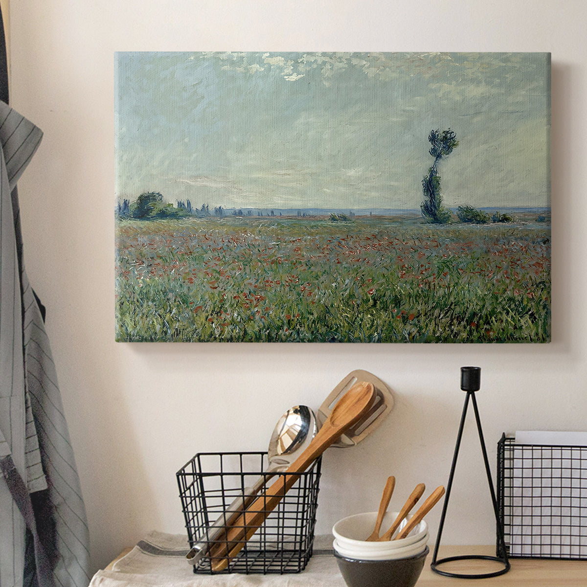 Canvas art print detailing a natural field scene with vibrant red flowers, displayed in a softly lit workspace setting