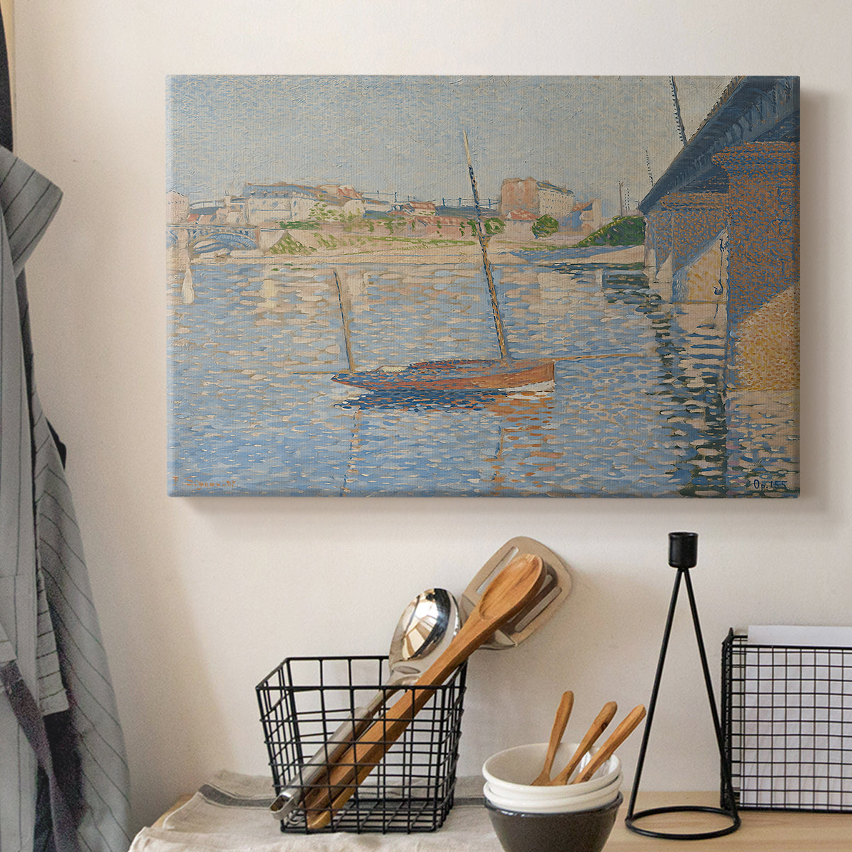 Canvas art print detailing a riverside composition with boats, displayed in a softly lit workspace setting