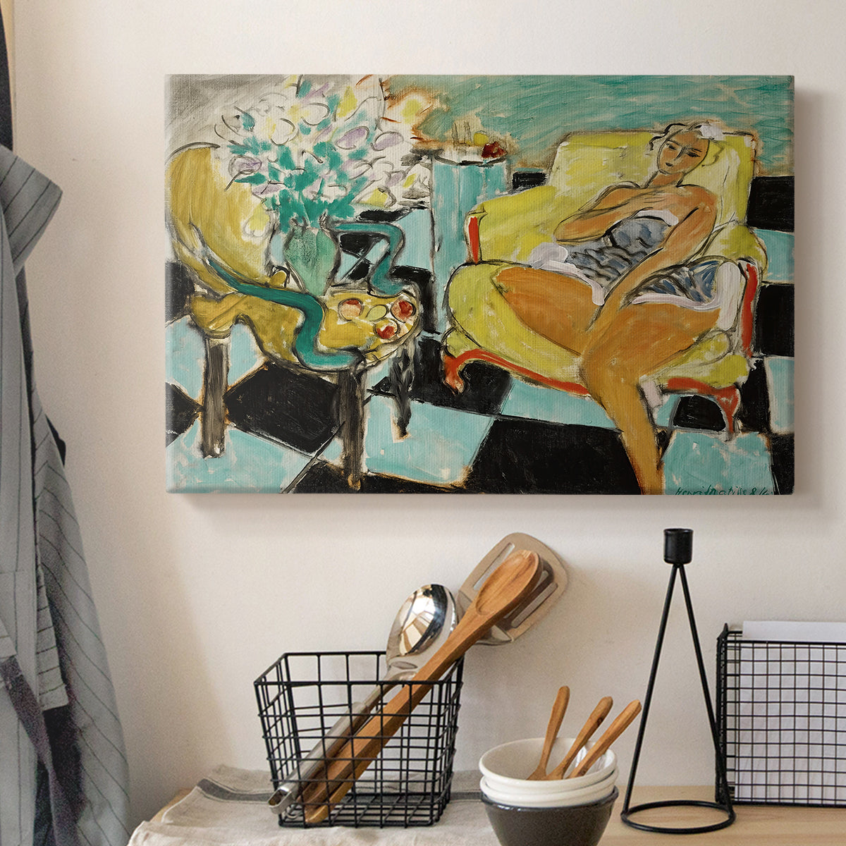 Canvas art print detailing a colorful seated portrait with a flower accent, displayed in a softly lit workspace setting