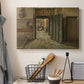 Canvas art print detailing an interior setting with figures positioned near doorway, displayed in a softly lit workspace setting