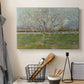 Canvas art print detailing a landscape emphasizing pattern of trees across field, displayed in a softly lit workspace setting
