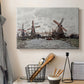Canvas art print detailing a landscape featuring windmills and low horizon sky, displayed in a softly lit workspace setting