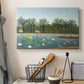 Canvas art print detailing a tropical landscape featuring birds and greenery, displayed in a softly lit workspace setting