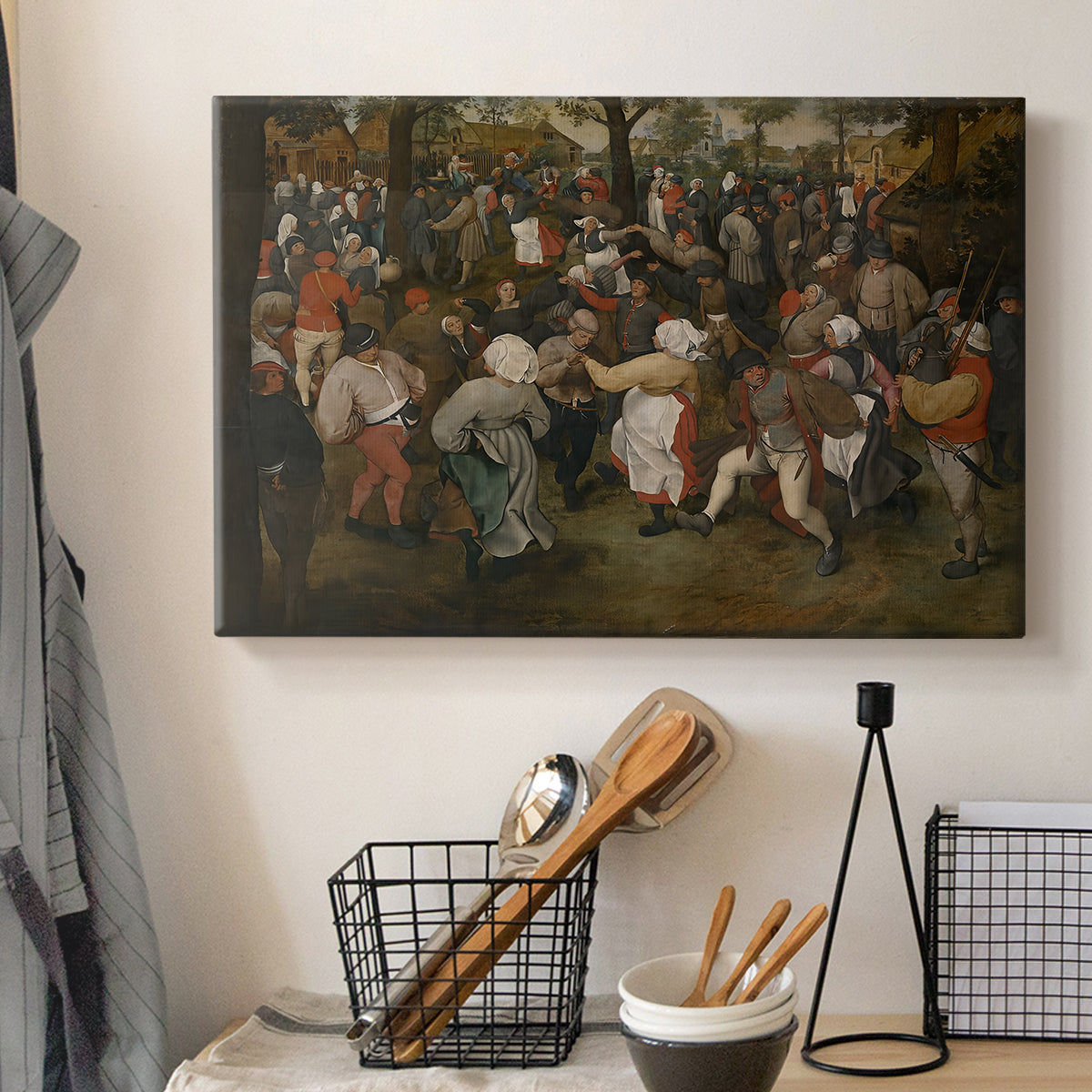 Canvas art print detailing a traditional wedding celebration scene, displayed in a softly lit workspace setting